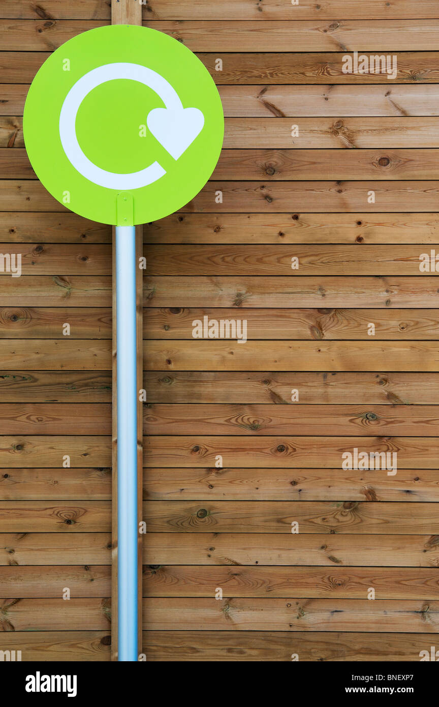 Segno di riciclo contro pannelli in legno in un supermercato in Inghilterra Foto Stock