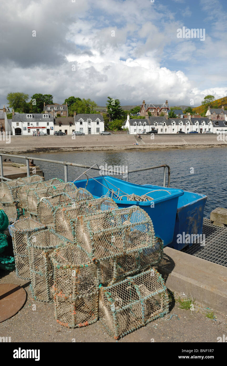 Astice in vasi o nasse sul lato dock a Ullapool in Ross and Cromarty Scozia con i villaggi di case a schiera dietro. Foto Stock