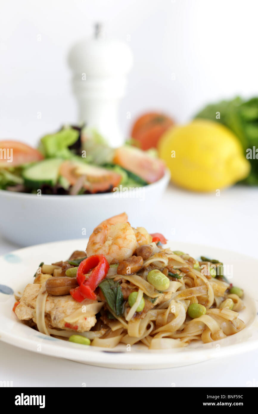 Autentico stile Thailandia Street Food Stir-Fried Pad Thai Noodles con pollo e gamberi contro uno sfondo bianco con n. di persone Foto Stock