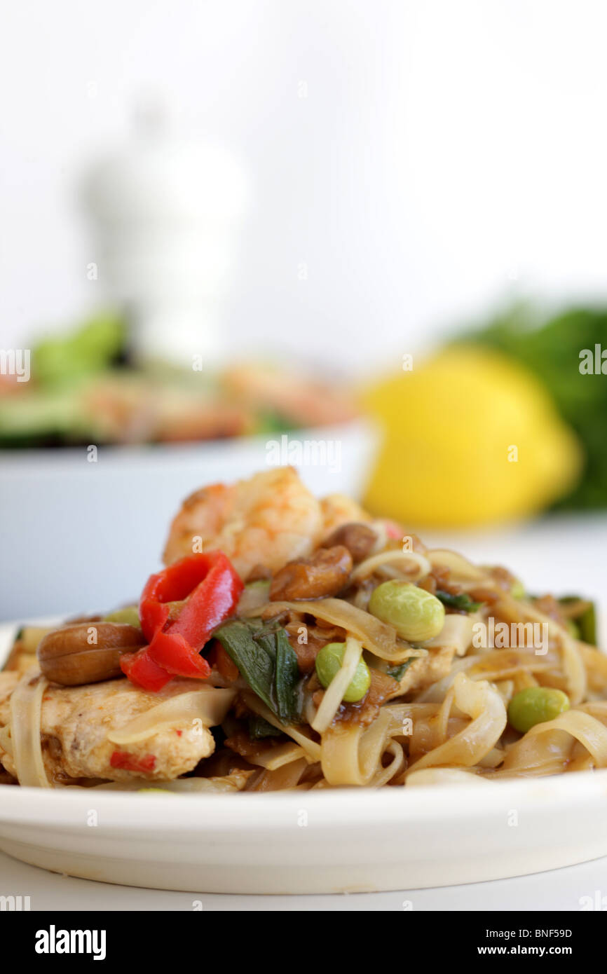 Autentico stile Thailandia Street Food Stir-Fried Pad Thai Noodles con pollo e gamberi contro uno sfondo bianco con n. di persone Foto Stock