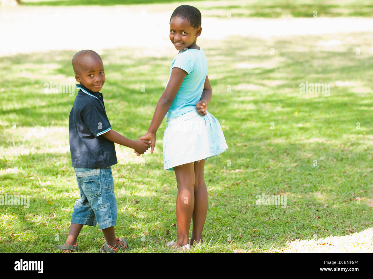 Ritratto di ragazzo e una ragazza (4-8) tenendo le mani in giardino, Johannesburg, provincia di Gauteng, Sud Africa Foto Stock