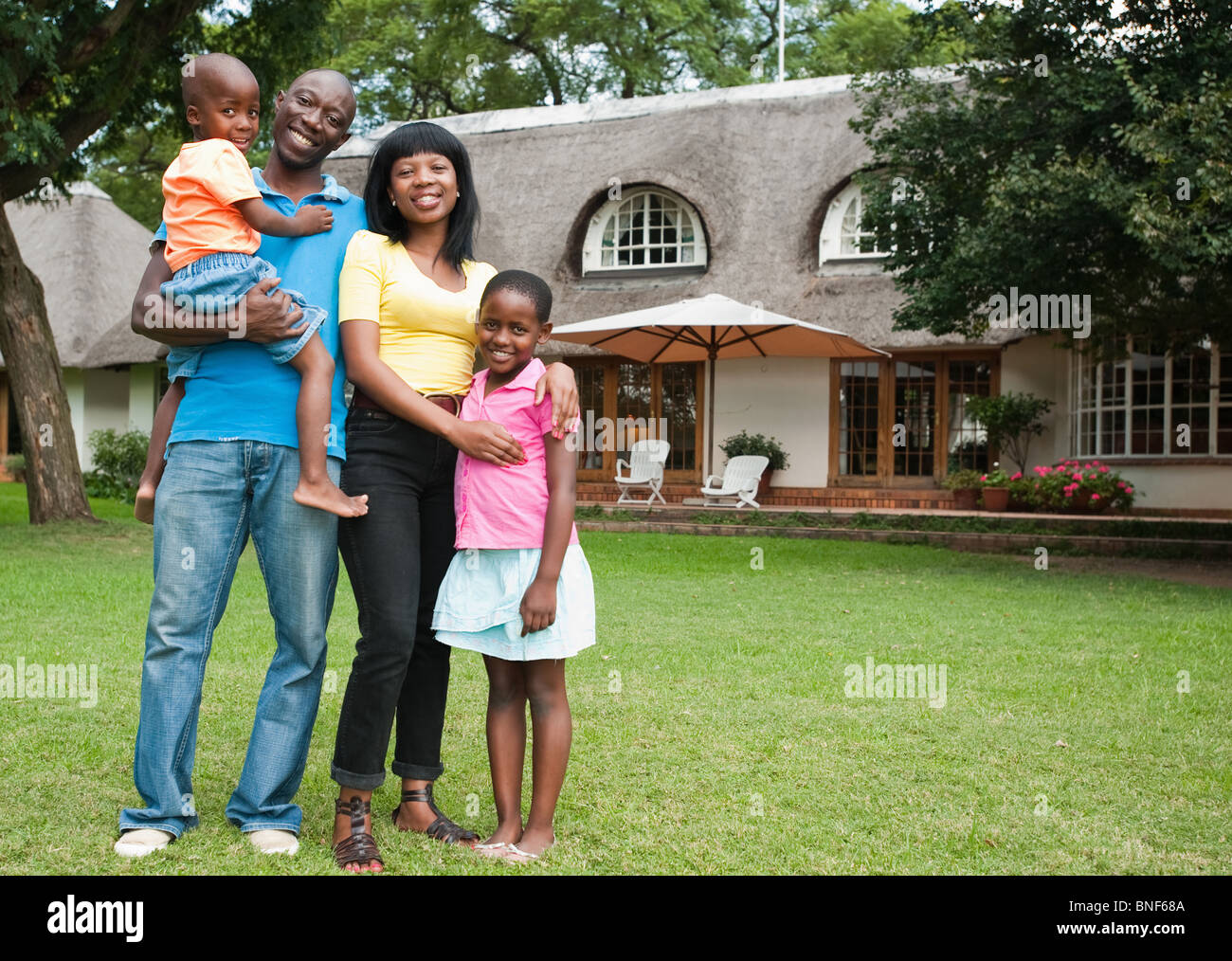 Ritratto di famiglia con bambini (4-8) nella parte anteriore della casa, Johannesburg, provincia di Gauteng, Sud Africa Foto Stock