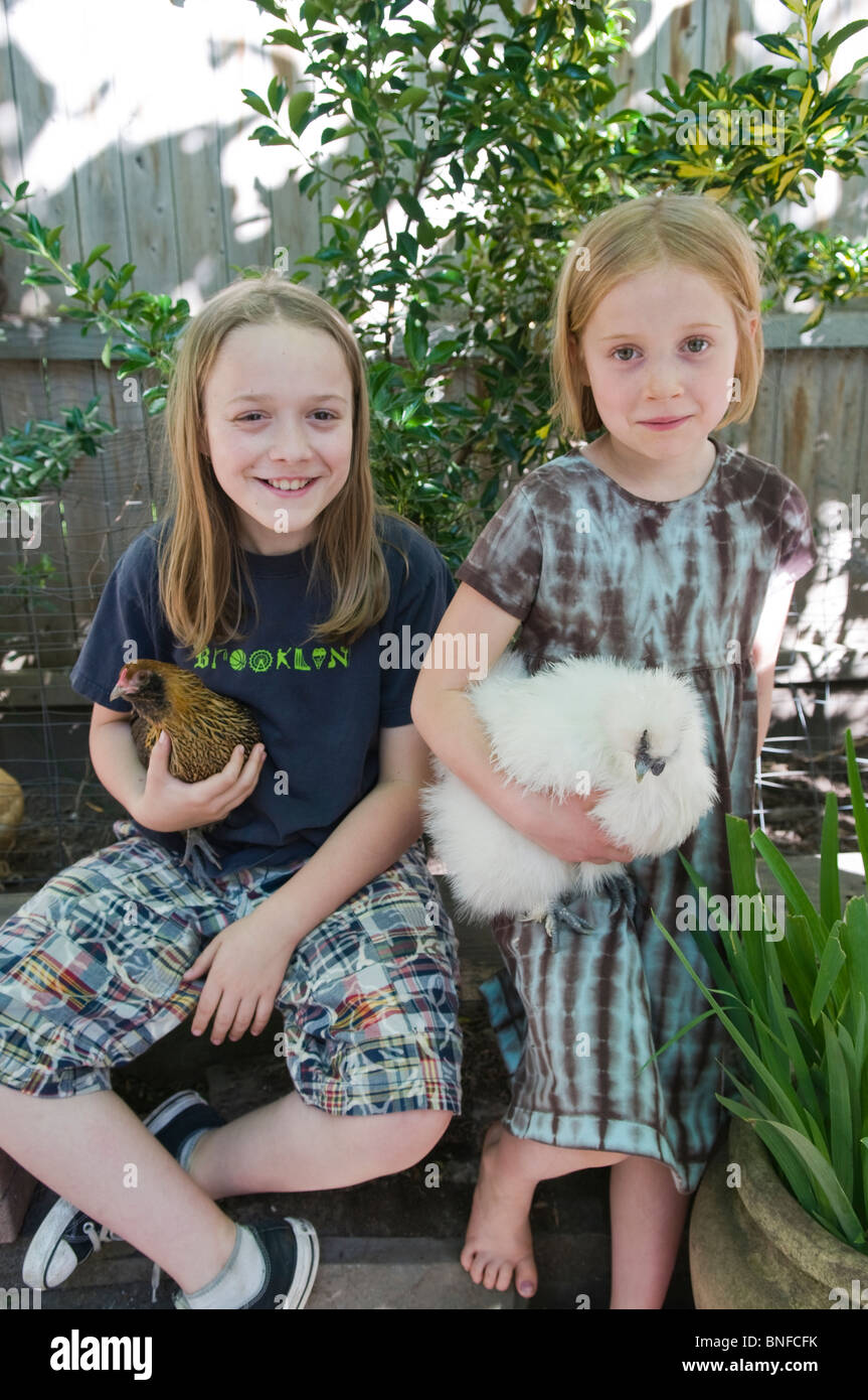 Bambini azienda polli nel cortile urbano pollaio Foto Stock