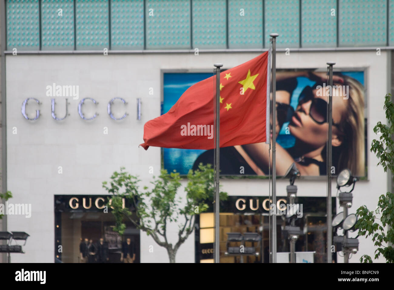Comunista cinese sventola bandiera nella parte anteriore del negozio di Gucci, Shanghai, Cina Foto Stock