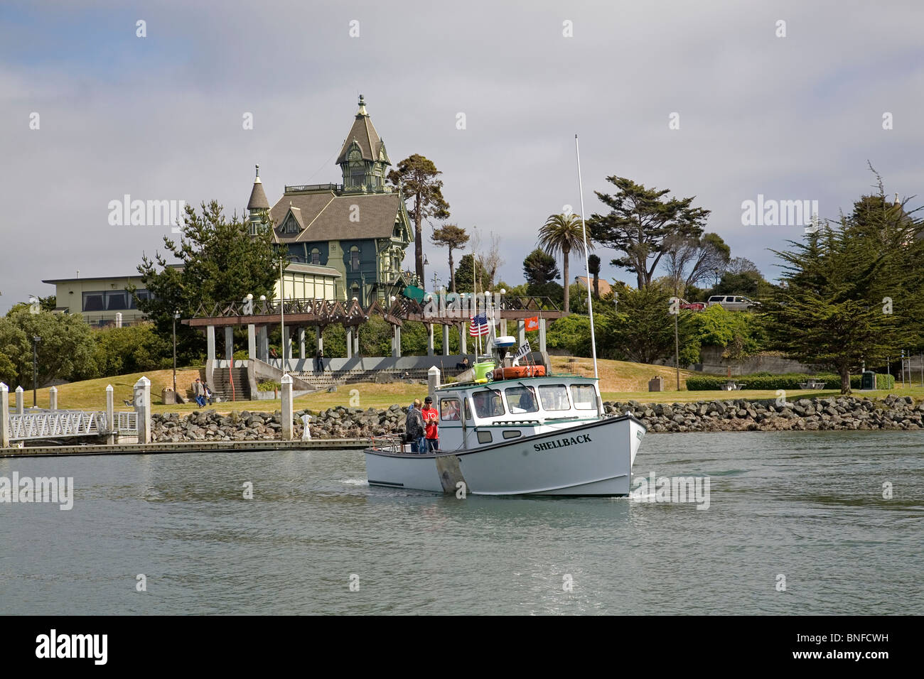 Una barca da pesca nel porto e il Club Ingomar o Carson Mansion, un Queen Anne Victorian House a Eureka, California. Foto Stock