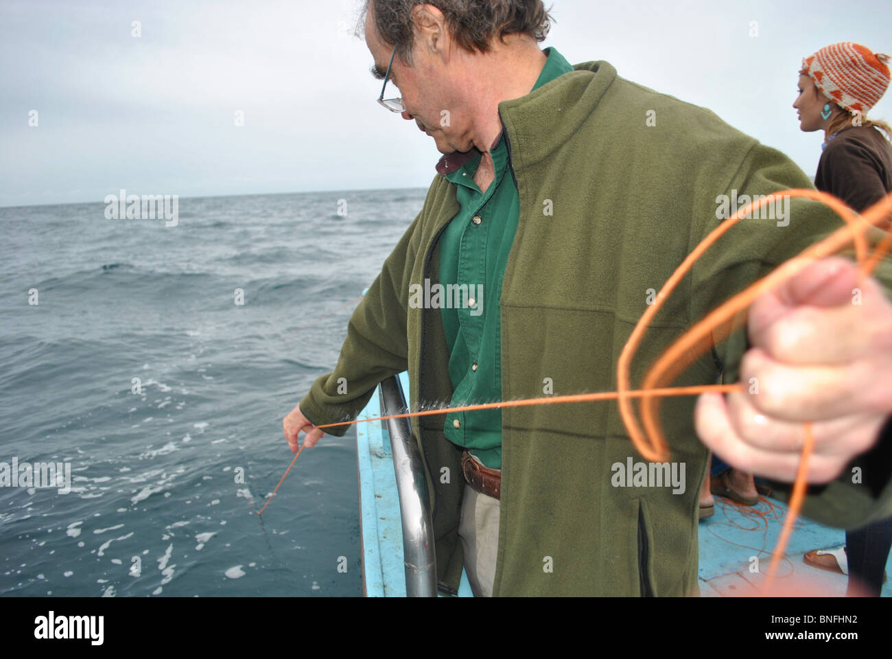 L'uomo la pesca dello sgombro fuori da una barca vicino al Lyme Regis, Dorset, Inghilterra Foto Stock