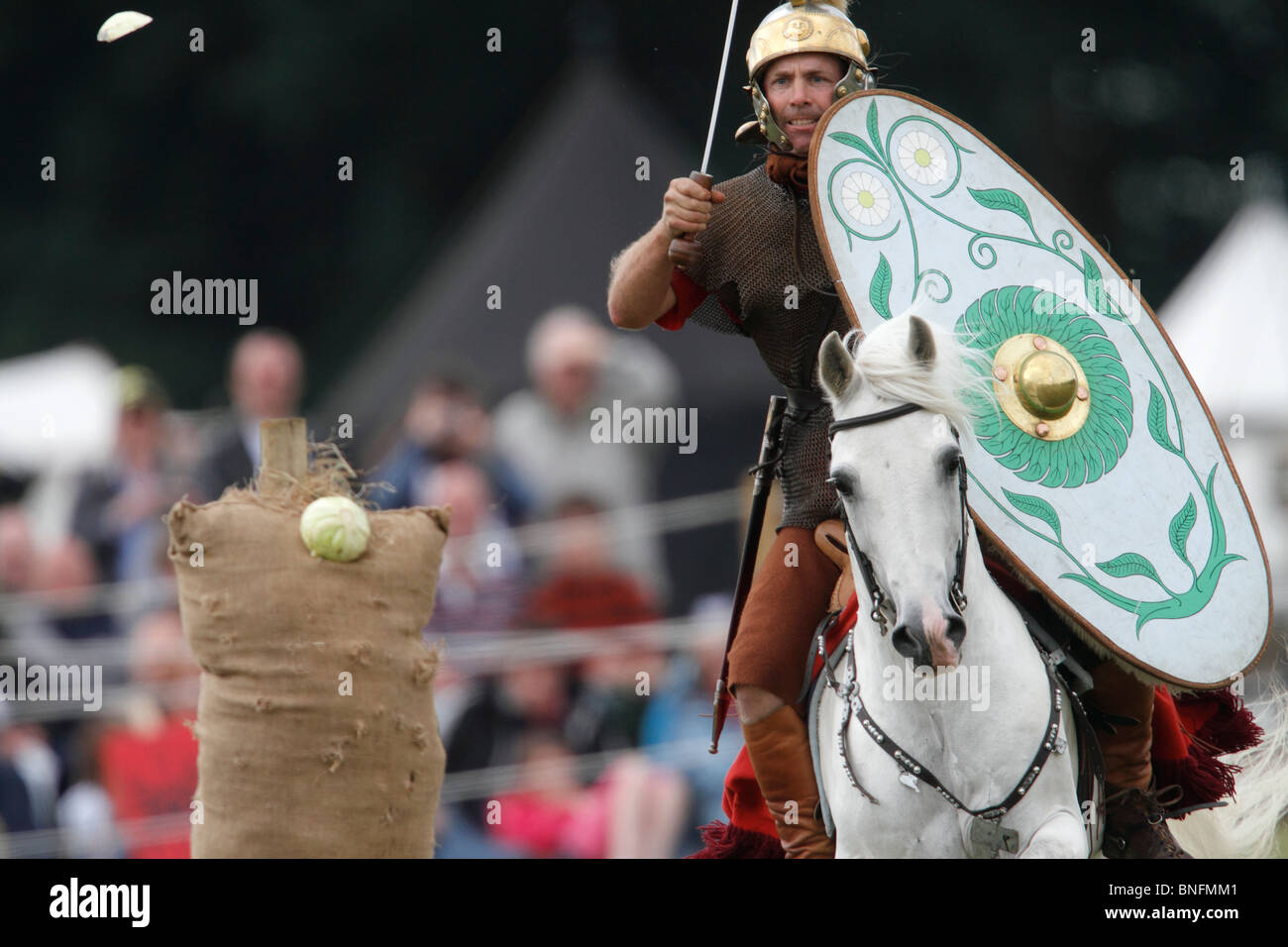 Roman cavalryman ausiliario pratica tagliando il cavolo sul galoppo Festival della storia 2010, Kelmarsh Hall, Northamptonshire. Ri-anactors rivivere la storia britannica dai romani per la seconda guerra mondiale Foto Stock