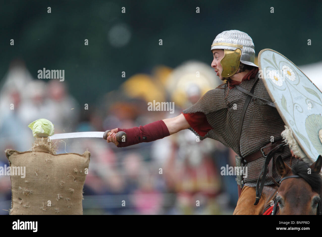 Roman cavalryman ausiliario pratica tagliando il cavolo sul galoppo Festival della storia 2010, Kelmarsh Hall, Northamptonshire. Ri-anactors rivivere la storia britannica dai romani per la seconda guerra mondiale Foto Stock