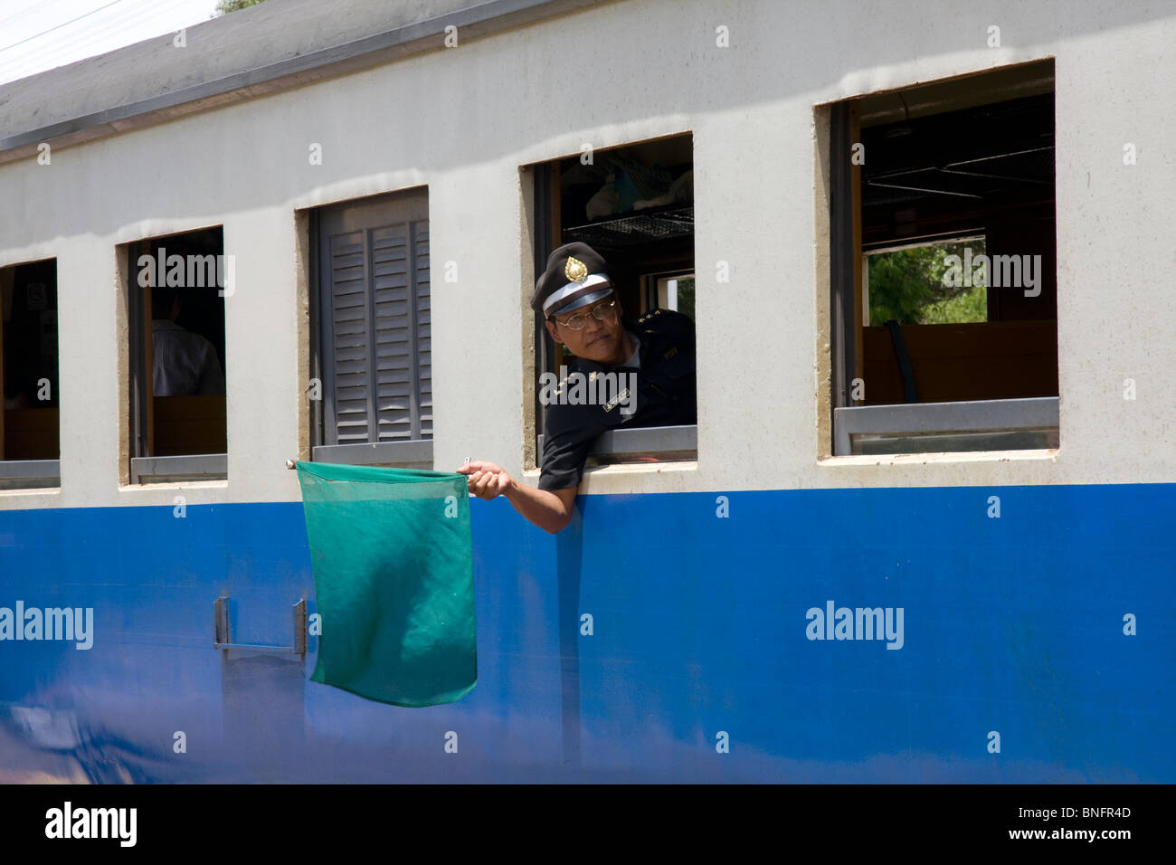Protezione del treno sventolare la bandiera verde dal treno a Hua Hin Stazione, Thailandia Foto Stock