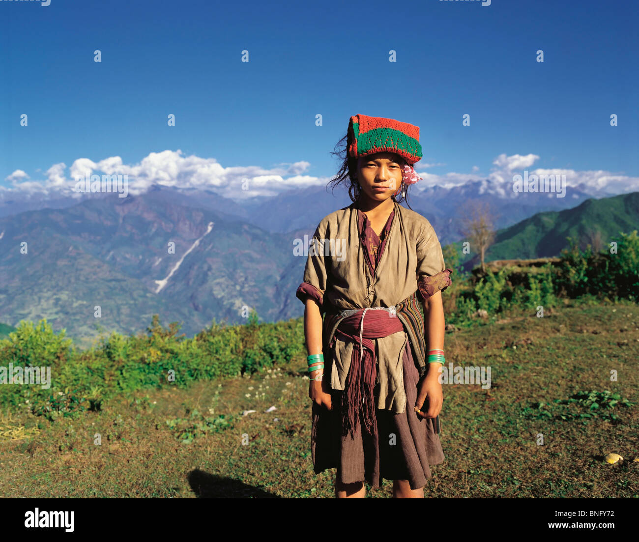 Un tribale Bhotia ragazza che lavora come un portiere prende un periodo di riposo dal suo carico sopra la valle di Arun nell est del Nepal Foto Stock