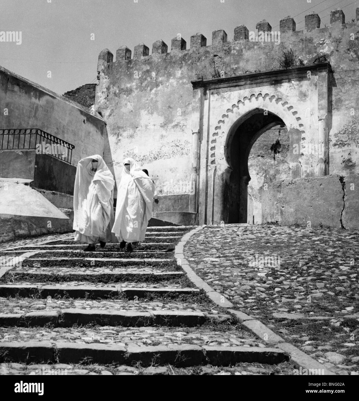 Tangeri, Marocco, due donne che indossano abiti tradizionali andando giù per le scale Foto Stock
