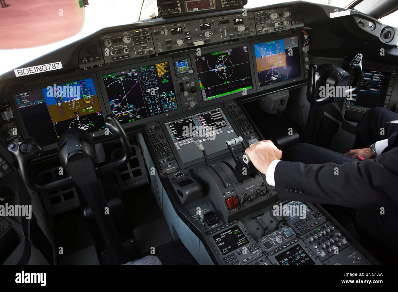 Nel cockpit di vetro degli schermi LCD, Boeing pilota con le mani sulle farfalle di 787 Dreamliner Foto Stock