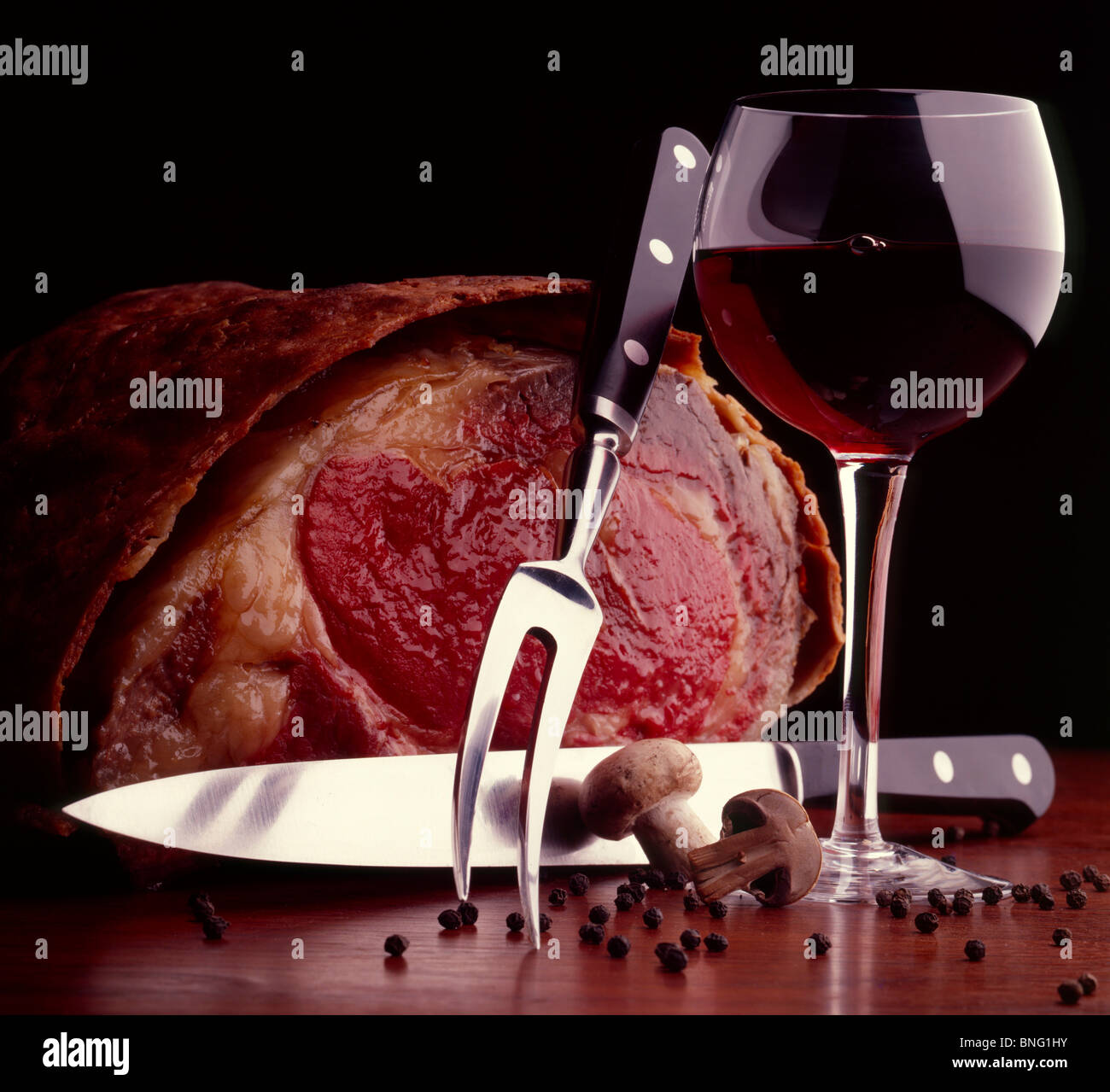 Raro arrosto di manzo con un coltello di intaglio e un bicchiere di vino  rosso Foto stock - Alamy