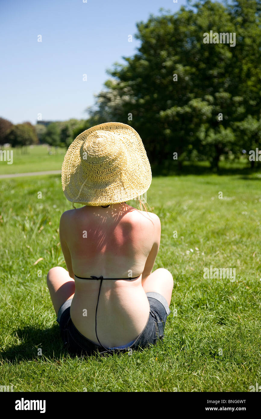 Sun bruciato ragazza con cappello di paglia in posizione di parcheggio Foto Stock