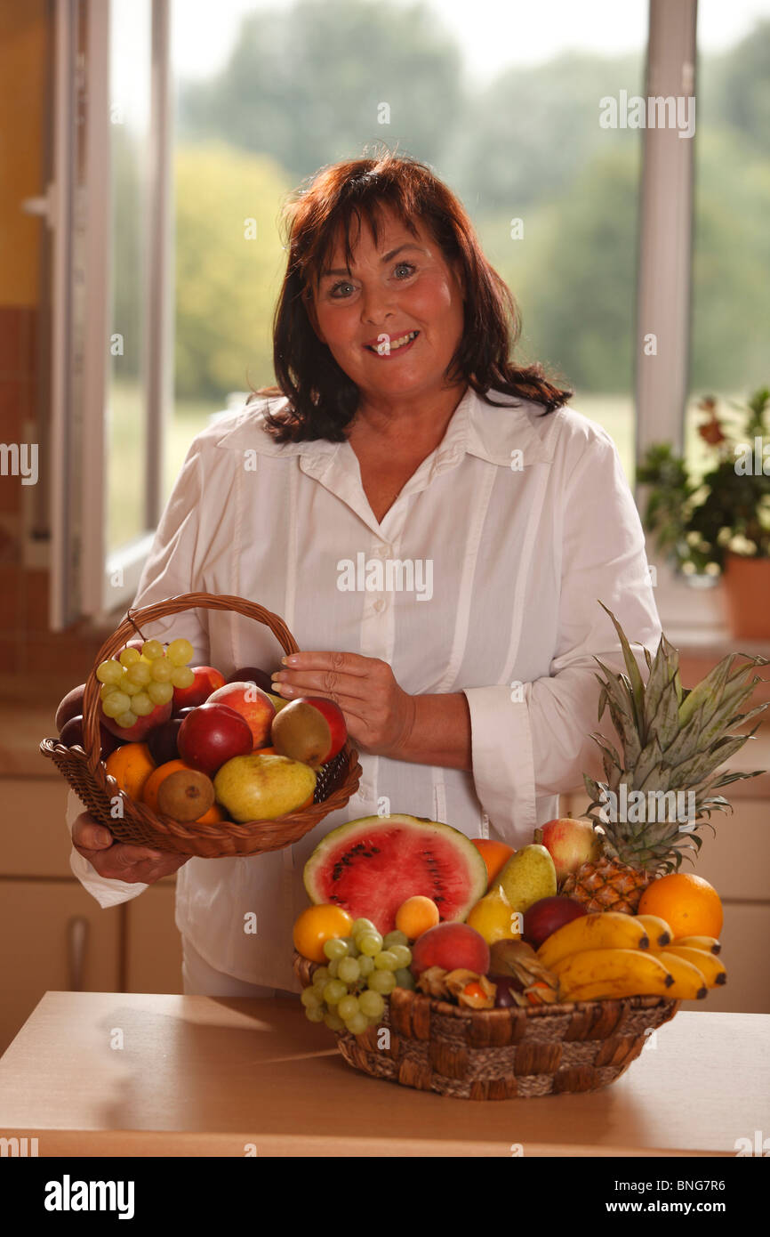 Donna con cesto di frutta Foto Stock