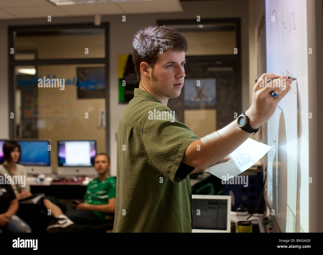 Maschio anglo di alta scuola studente lavora un problema di matematica su interattivo di un bordo bianco a Manor New Tech High in maniero, Texas. Foto Stock