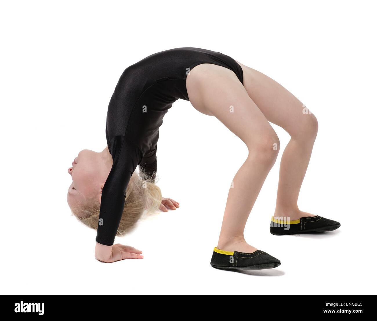 Piccola ragazza ginnasta facendo esercizio isolato su bianco Foto Stock