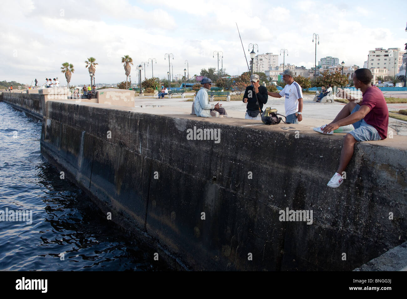 Gli uomini di pesca e di socializzazione sul Malecon lungomare Avana Cuba Foto Stock
