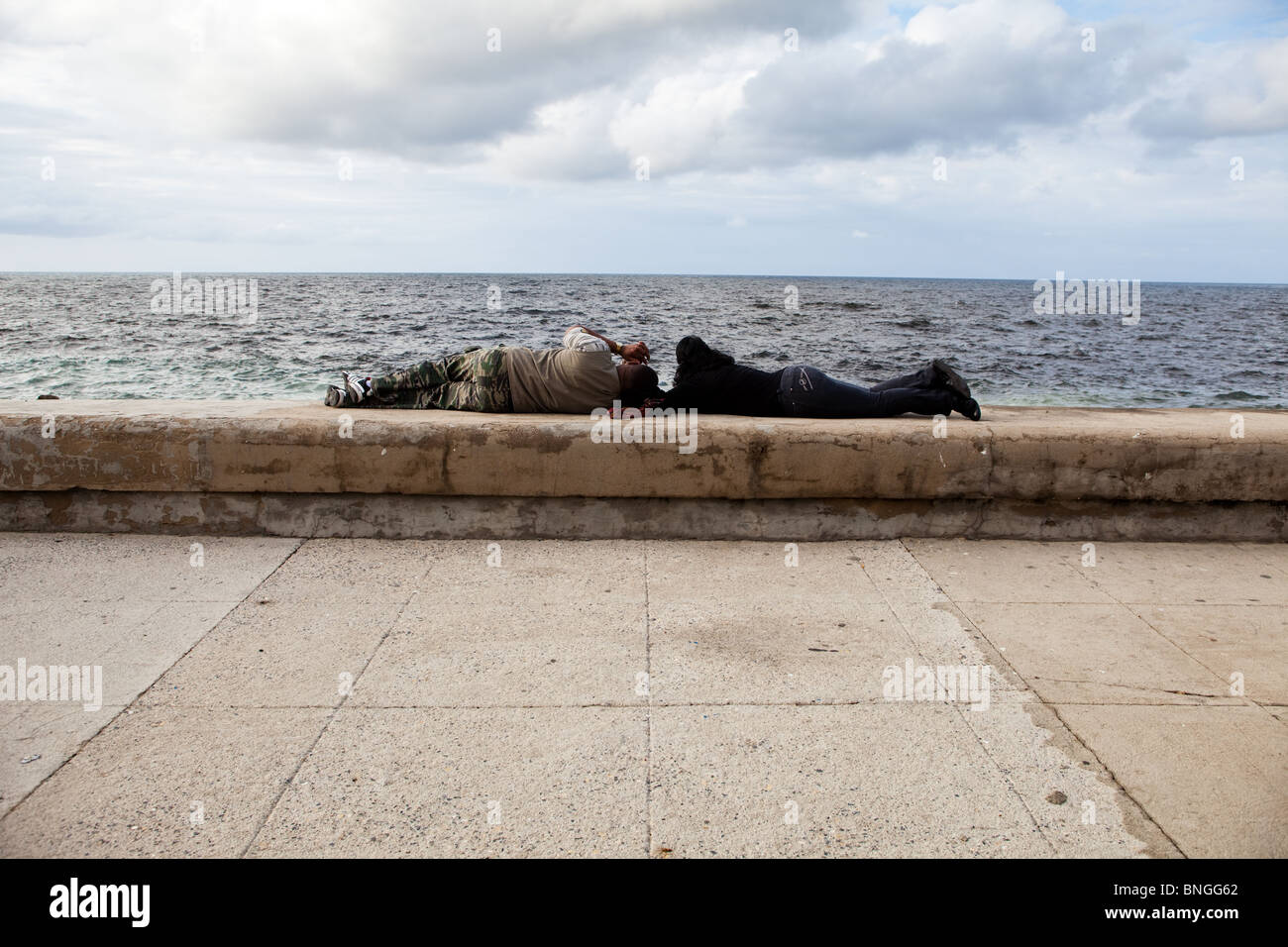 Due amanti giacciono testa a testa sul Malecon lungomare Avana Cuba Foto Stock