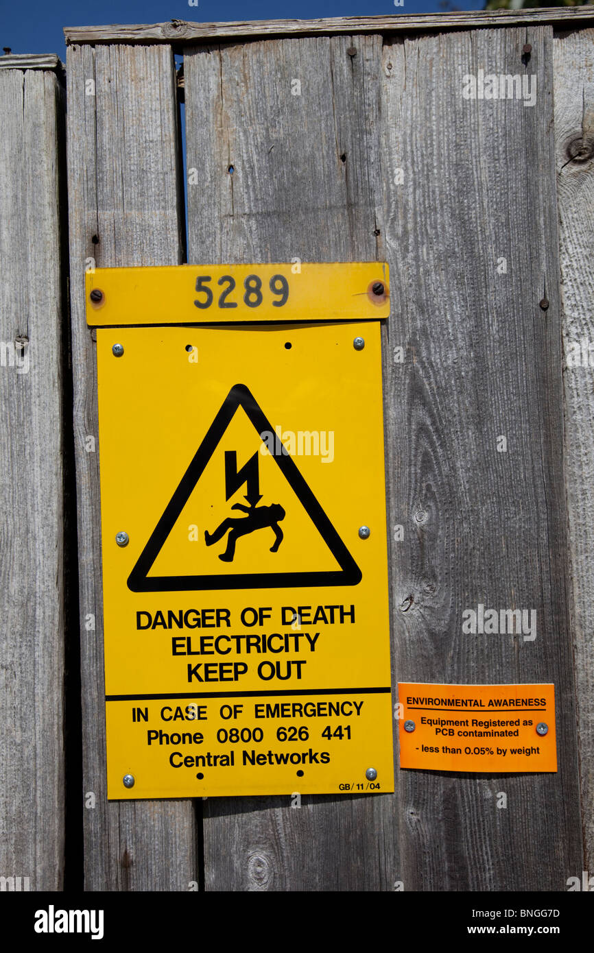 Di colore giallo brillante pericolo di morte elettricità segno di avvertimento tenere fuori il recinto REGNO UNITO Foto Stock