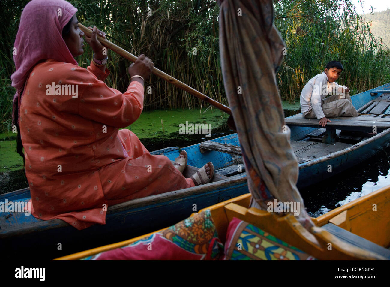 La gente in una barca shikara incontrato durante una shikara gita in barca dal lago a Srinagar, Jammu e Kashmir in India. Foto Stock