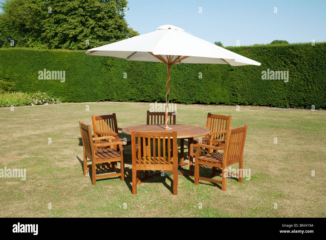 Tavolo da giardino sdraio ed ombrellone su una giornata d'estate nel Kent, Regno Unito Foto Stock
