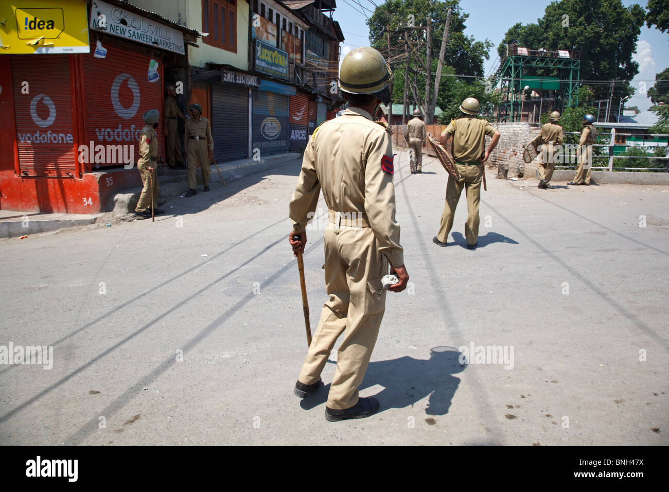 La polizia combatte con adolescenti che lanciano pietre contro di loro durante i tumulti a Srinagar, Jammu e Kashmir in India. Foto Stock