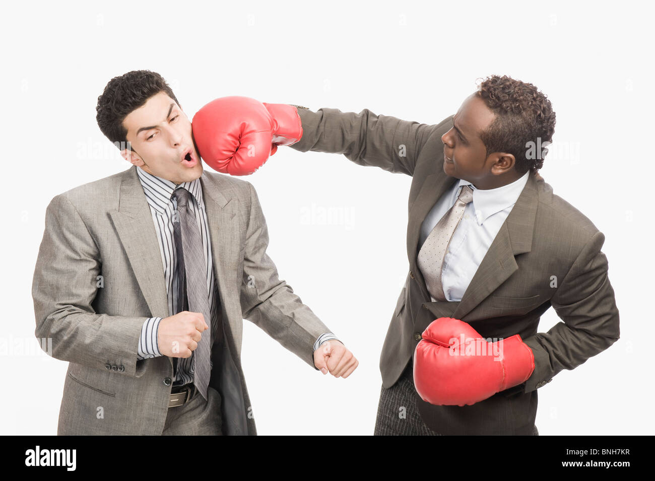 Imprenditore punzonatura il suo co-lavoratore con i guantoni da pugilato Foto Stock