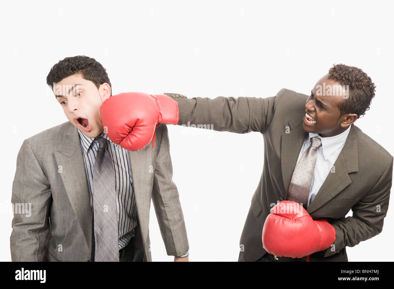 Imprenditore punzonatura il suo co-lavoratore con i guantoni da pugilato Foto Stock