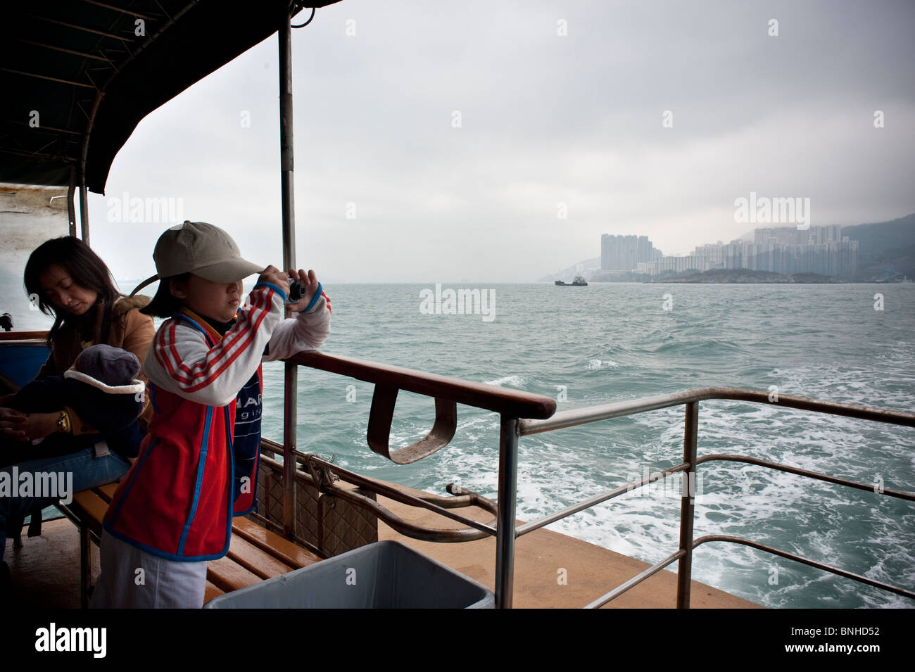 Hong Kong, Lamma canale,giovane ragazza prende l'immagine sul traghetto fino all'Isola di Lamma. Foto Stock