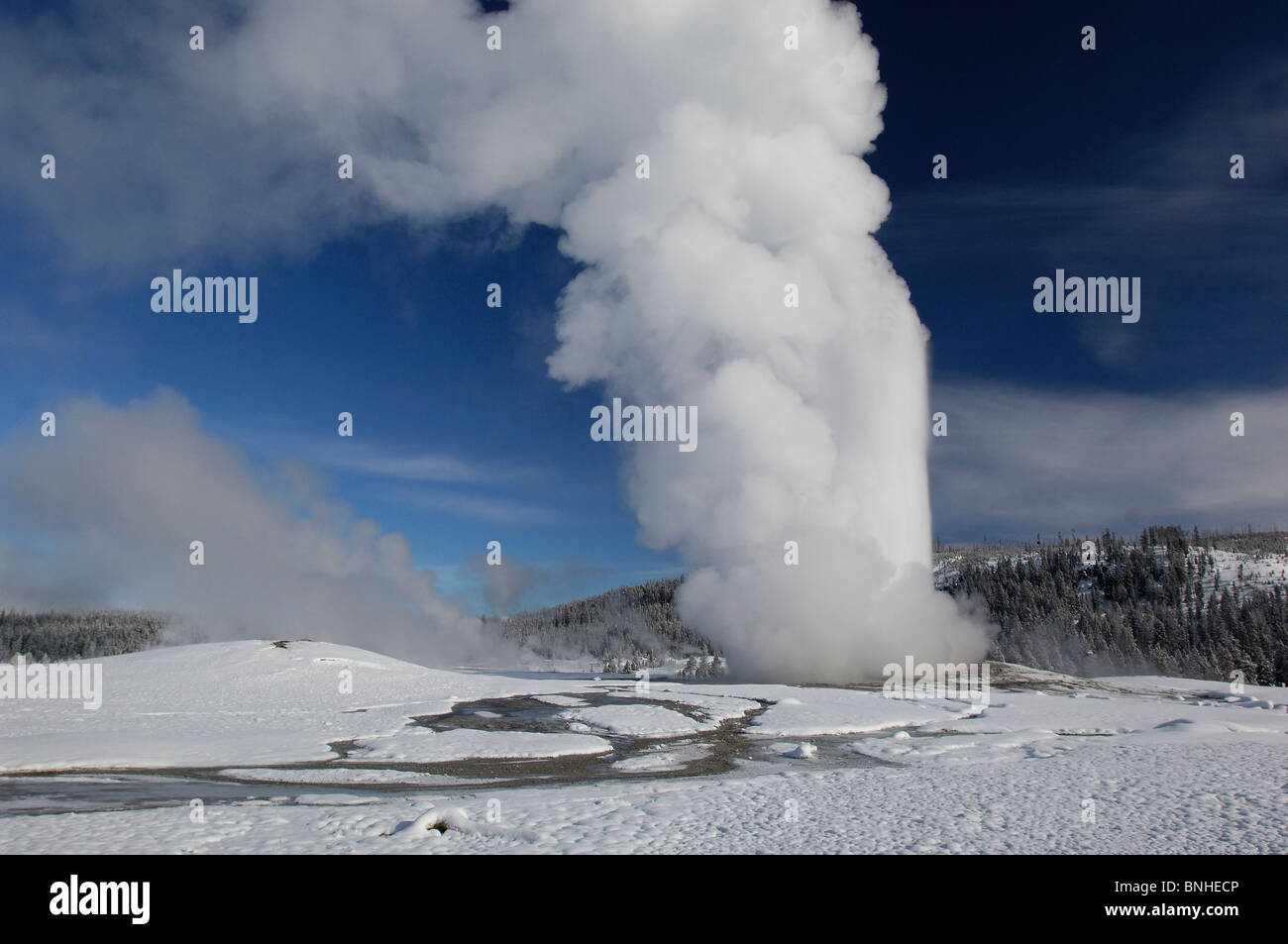 Stati Uniti d'America Wyoming geyser Old Faithful eruzione neve il Parco Nazionale di Yellowstone inverno vulcanismo vulcanica natura paesaggio paesaggio blu Foto Stock