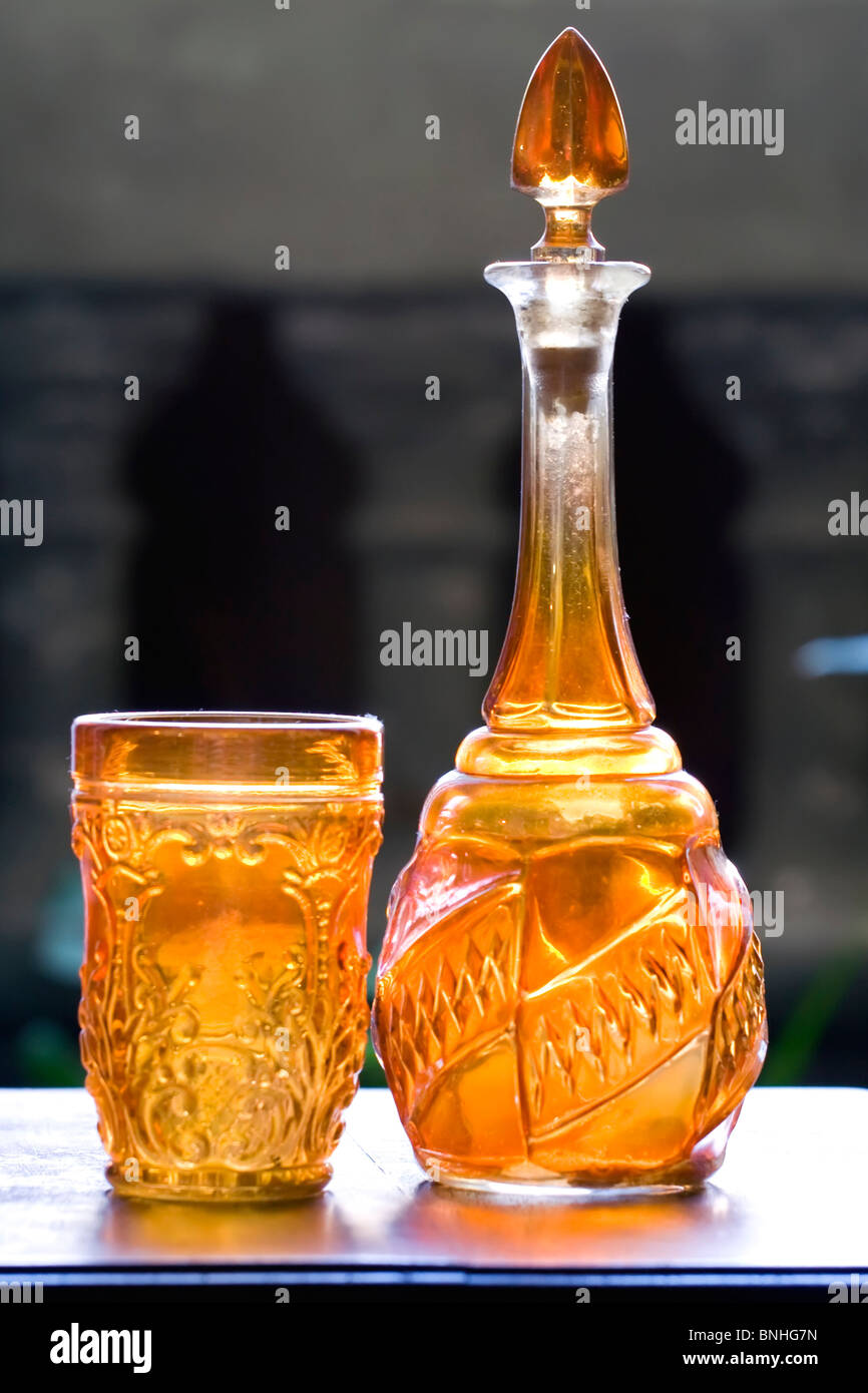 Arancione vecchia bottiglia di vetro e vetro dello stesso colore Foto Stock