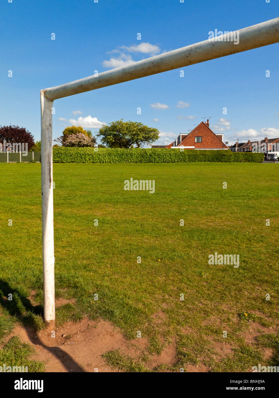 Obiettivo posti su un campo di calcio o di calcio in un parco suburbano con case dietro Foto Stock