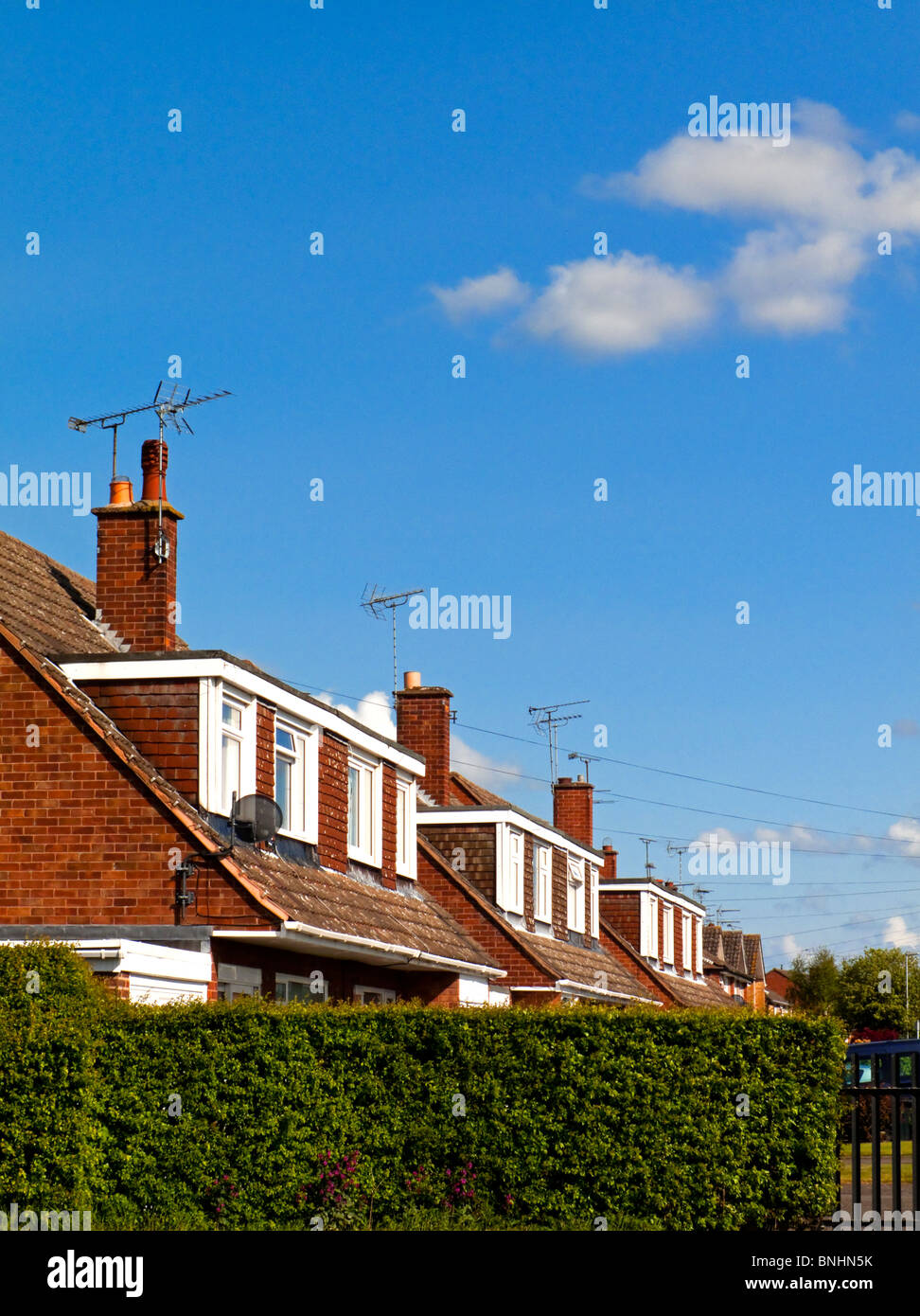 Alloggiamento suburbane nel Regno Unito con degli anni settanta stile case con tetti spioventi e finestre dormer Foto Stock