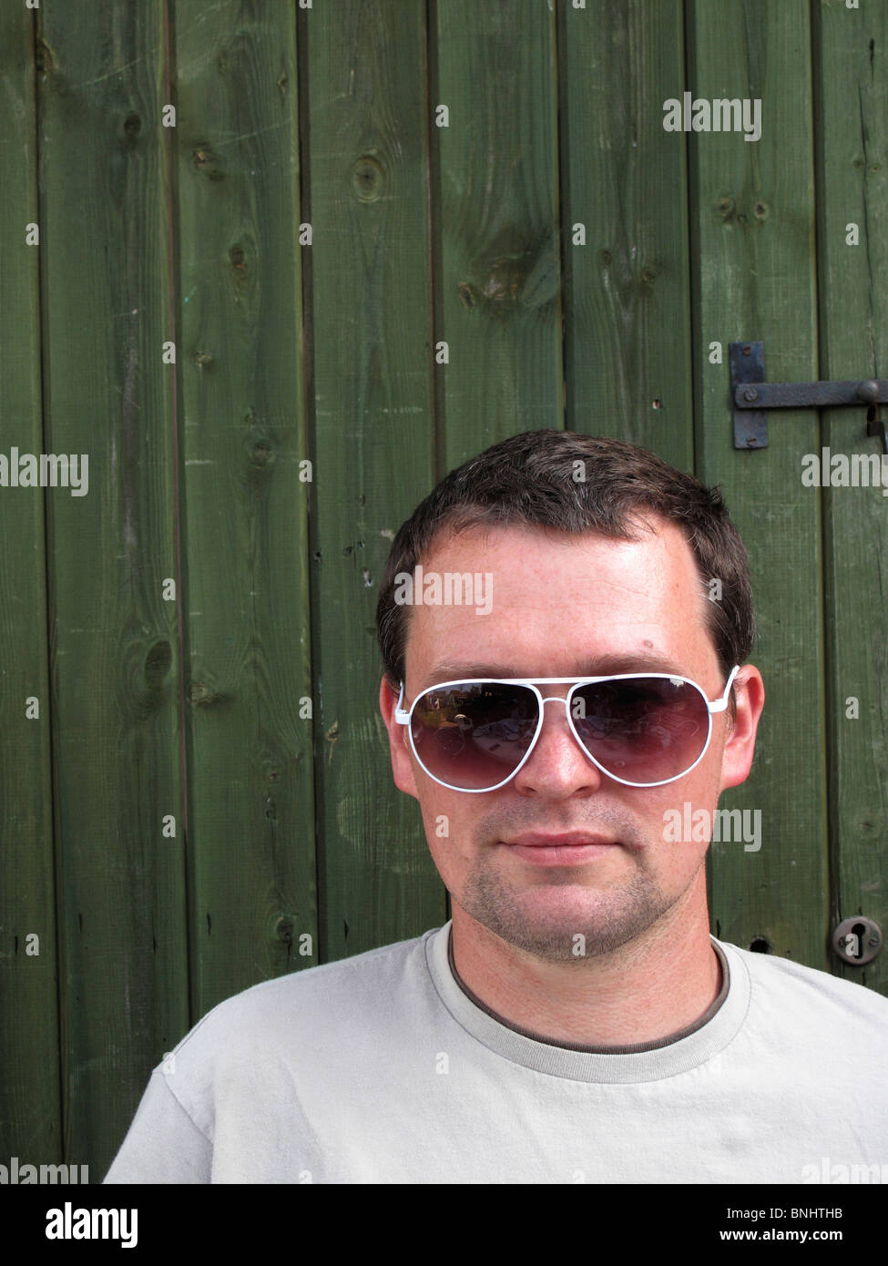 Giovane uomo in bianco incorniciato occhiali da sole Foto Stock