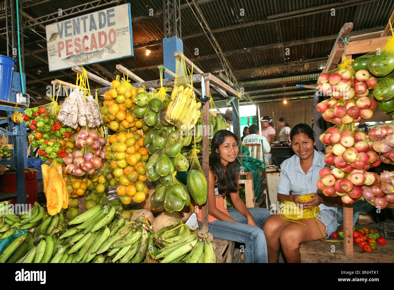 Leticia Colombia città mercato di legumi Ortaggi frutta pesce fornitori fornitori le donne ridere di stallo popolo degli scambi interni all'interno Foto Stock