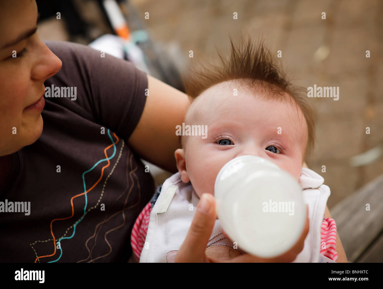 Giovane madre bottiglia alimenta il bambino. Foto Stock