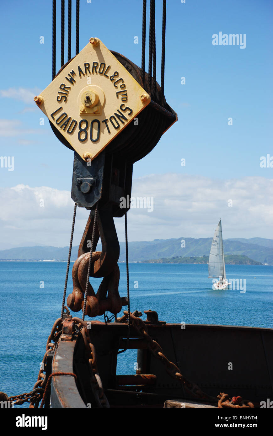 Wellington Waterfront, prese con verricello di una gru storico nave in primo piano e yacht a vela sul mare in background Foto Stock