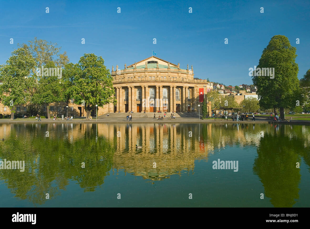 La città di Stoccarda Germania Baden-Wurttemberg teatro classico Grosses Haus pond parco alberato di riflessione persona a molla, Foto Stock