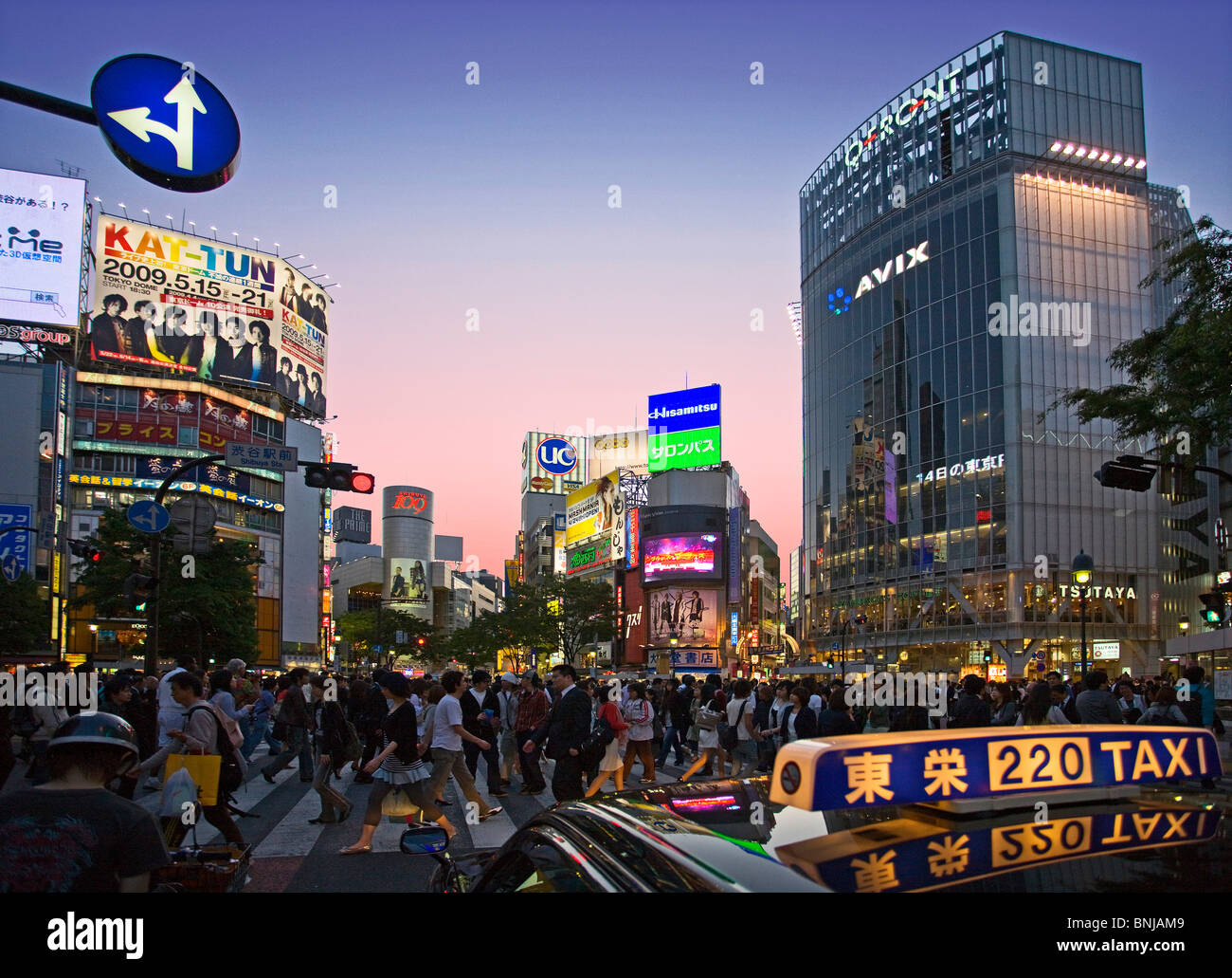 Asia Giappone Tokyo città quartiere Shibuya di sera il traffico pedonale passer-da costruzione edilizia luci al neon taxi Foto Stock