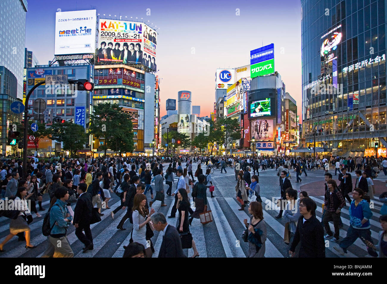 Asia Giappone Tokyo città quartiere Shibuya di sera il traffico pedonale passer-da costruzione edilizia luci al neon folla Foto Stock