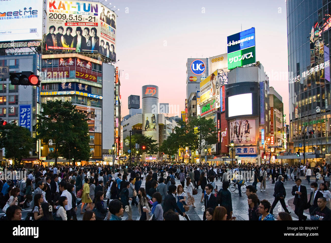 Asia Giappone Tokyo città quartiere Shibuya di sera il traffico pedonale passer-da costruzione edilizia luci al neon folla Foto Stock