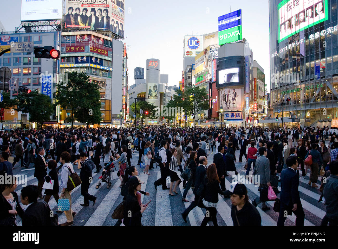 Asia Giappone Tokyo città quartiere Shibuya di sera il traffico pedonale passer-da costruzione edilizia luci al neon folla Foto Stock