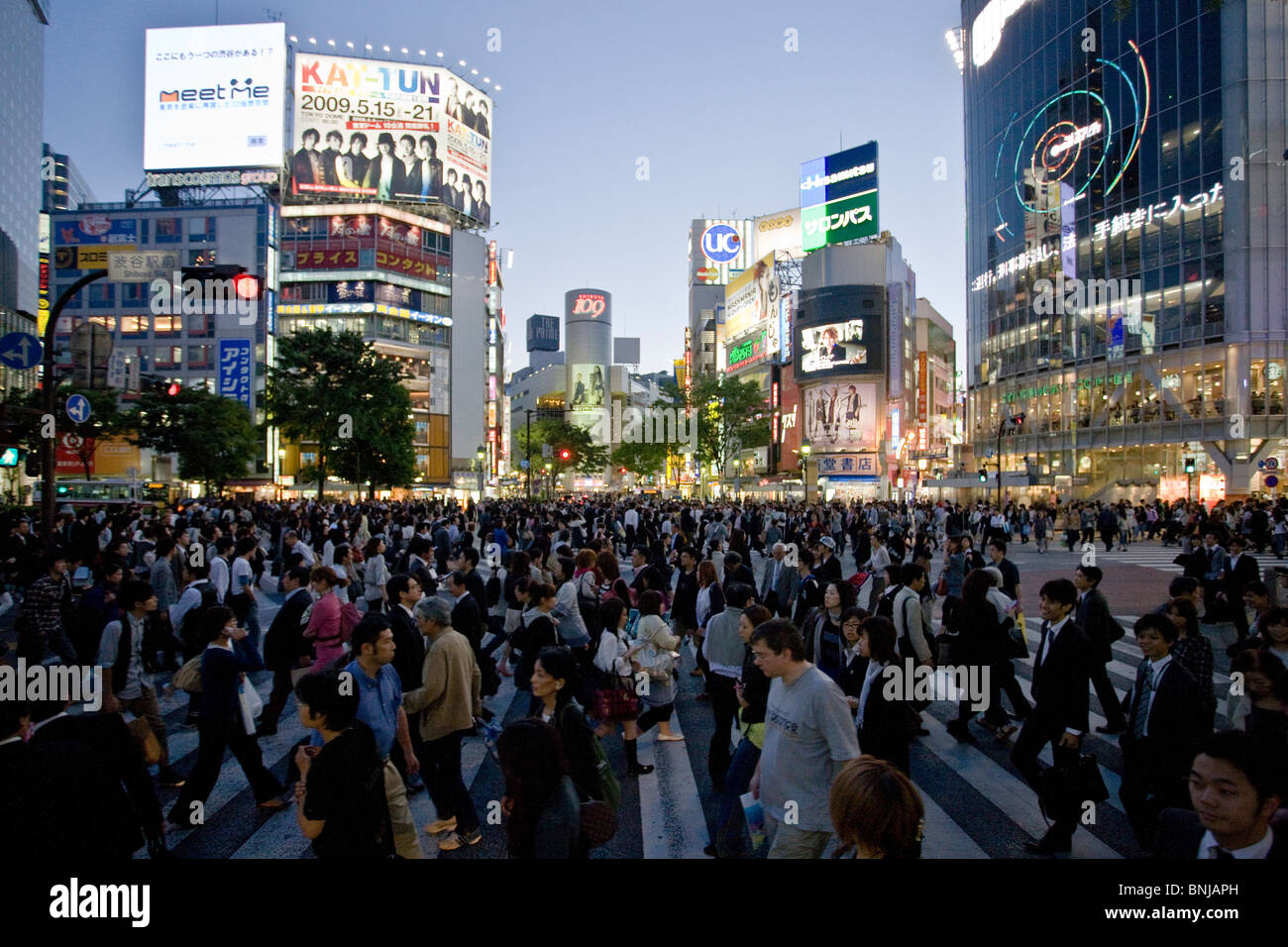 Asia Giappone Tokyo città quartiere Shibuya di sera il traffico pedonale passer-da costruzione edilizia luci al neon folla Foto Stock