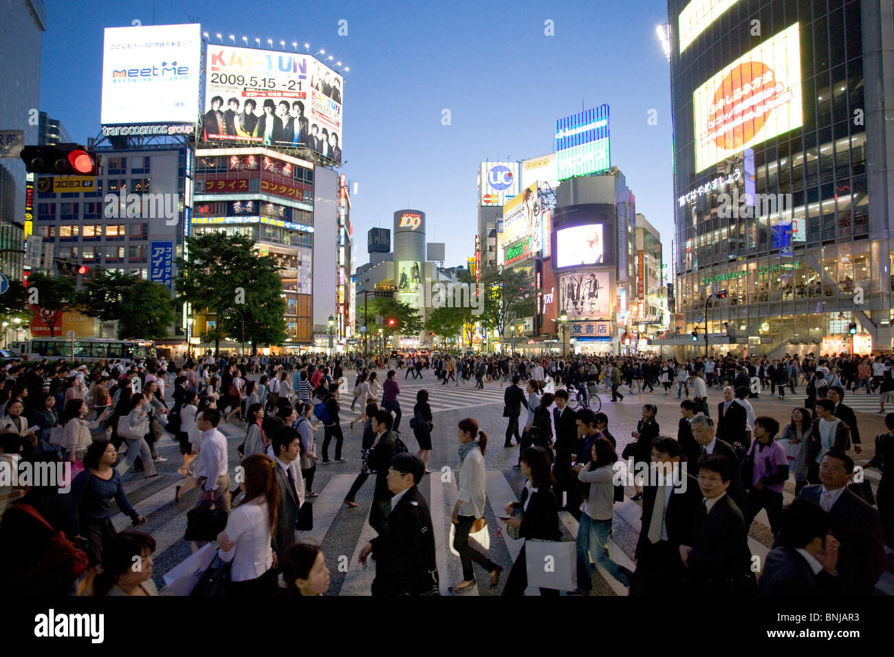 Asia Giappone Tokyo città quartiere Shibuya di sera il traffico pedonale passer-da costruzione edilizia luci al neon folla Foto Stock