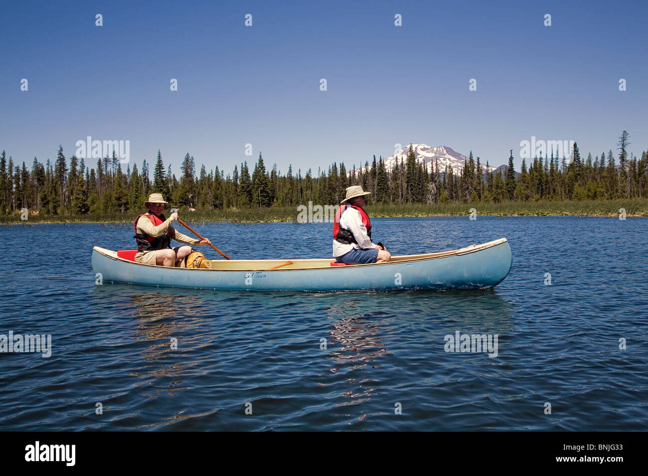 I cittadini anziani pagaiare in canoa sul lago Hosmer lungo la cascata Autostrada dei Laghi in Oregon Cascades Foto Stock