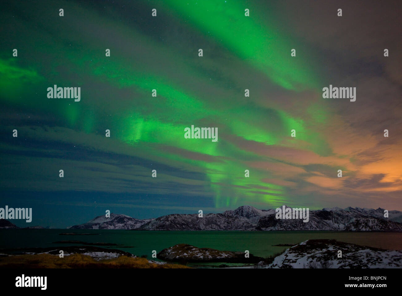 Sommaroy Norvegia Scandinavia luce polare fenomeno naturale della luce del nord aurora notte invernale nuvole mare montagne neve Foto Stock