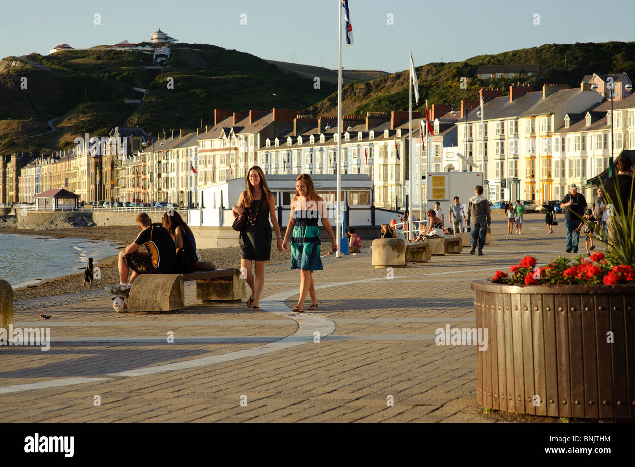 Persone che passeggiano sul lungomare in una serata estiva, Aberystwyth Wales UK Foto Stock