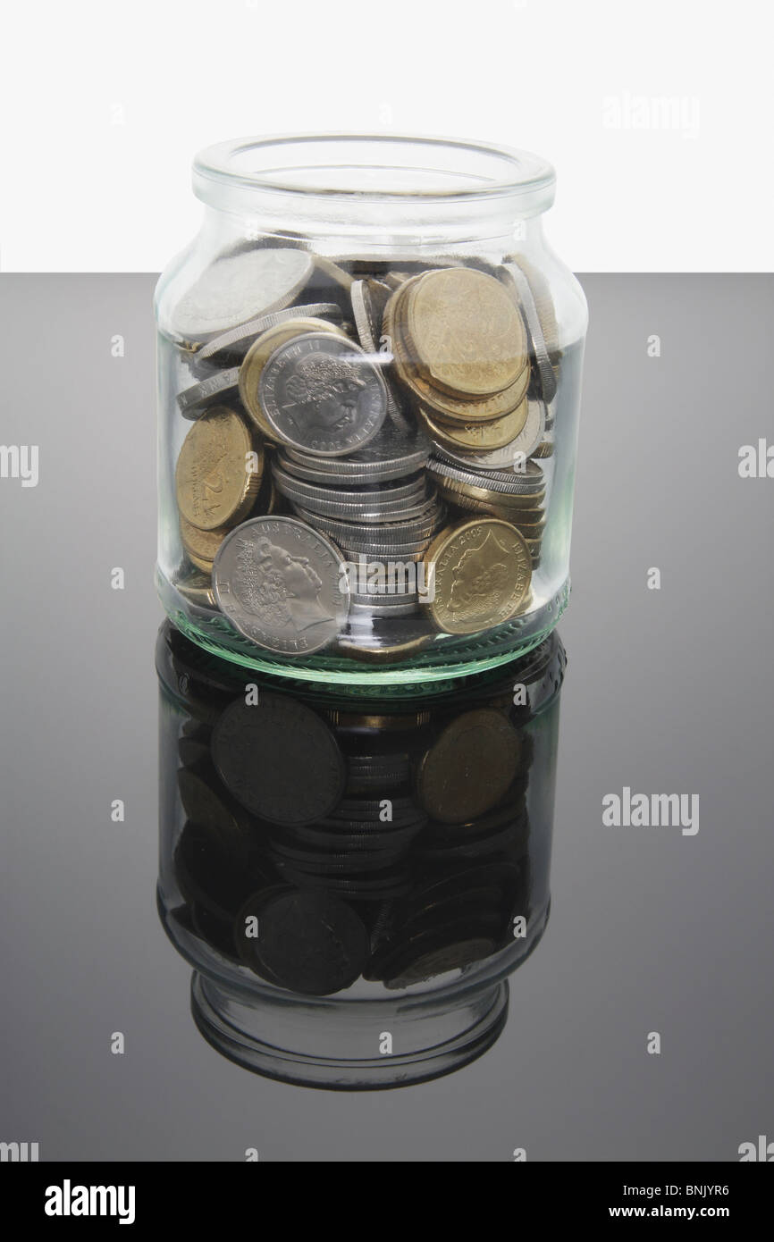Le monete in un barattolo di vetro Foto Stock