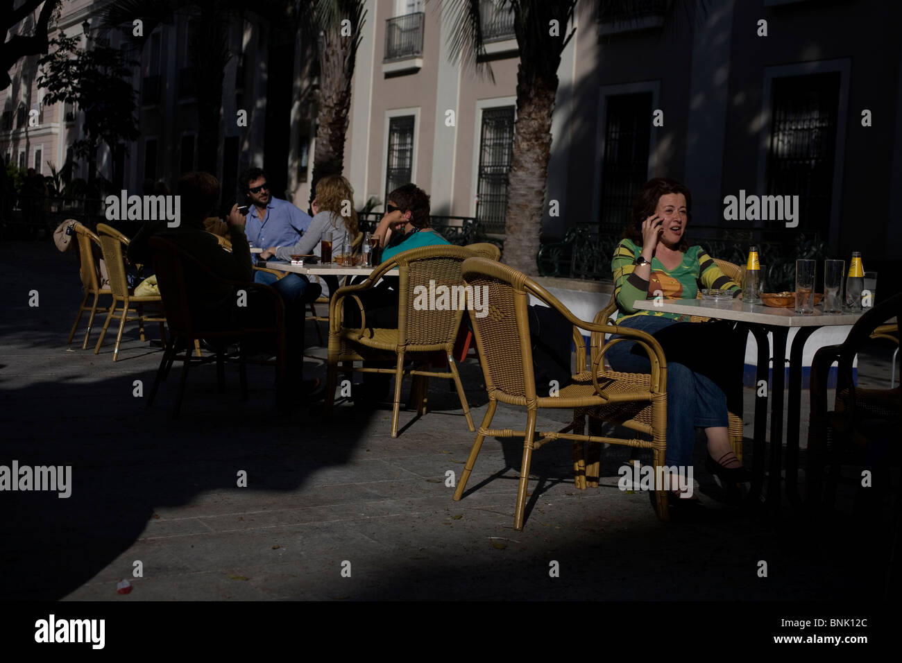 Una donna parla sul suo telefono cellulare sulla terrazza di un caffè bar a Cadice, Andalusia, Spagna, 17 aprile 2010. Foto Stock